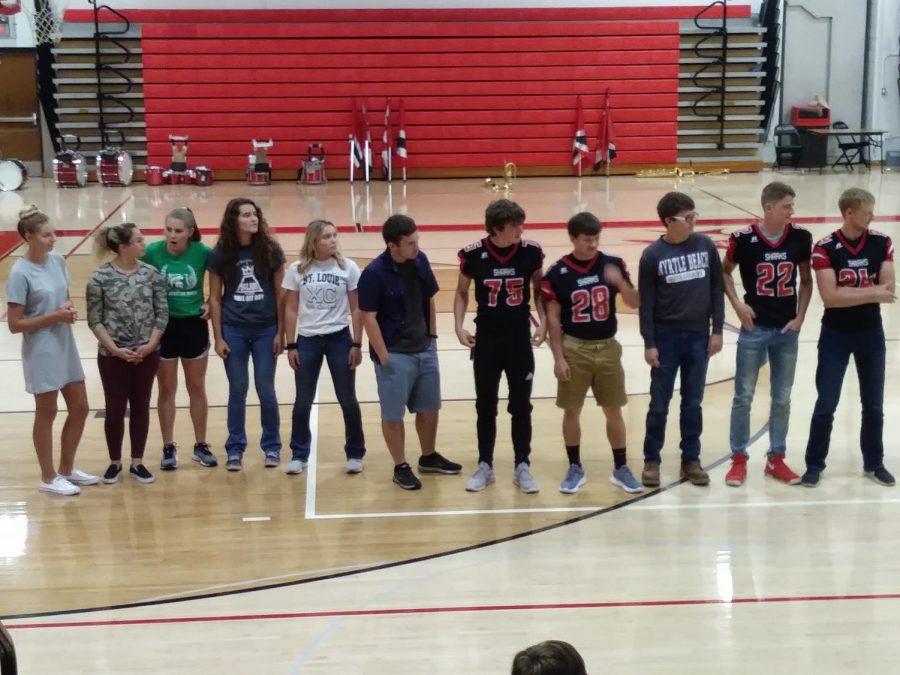 The senior class homecoming representatives stand, listening and shocked, as administration reveals that they all were confirmed for court.