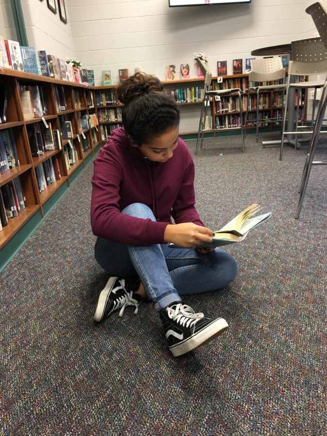 SLHS Student reads To All the Boys Ive Loved in the library.
