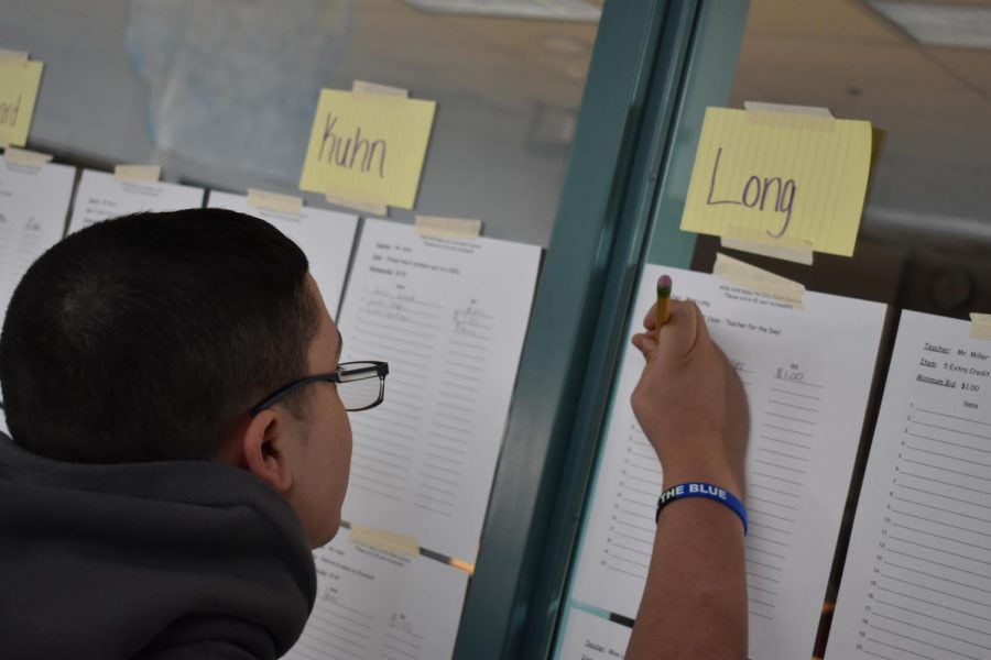 Student writes their bid on the item offered by the teacher.