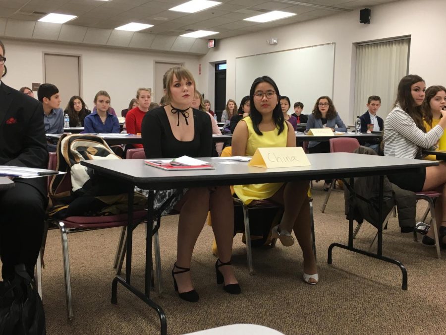 Kira Dowell and Chau Nguyen sit at their table representing their country.