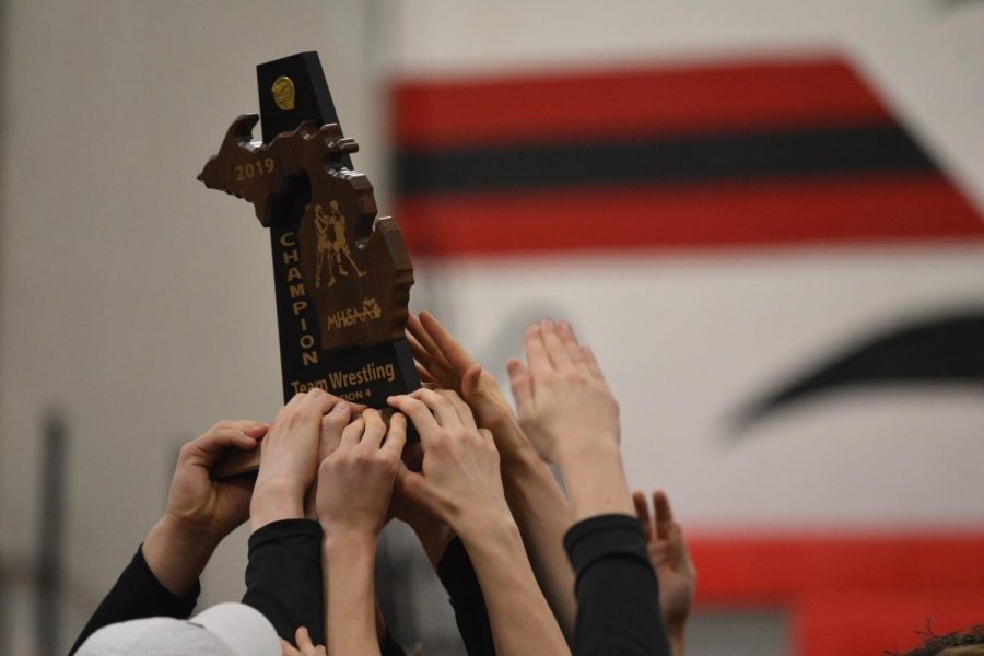 St. Louis wrestlers hoist their Division champion trophy.