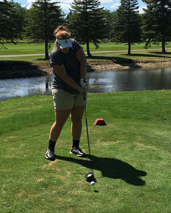 Skylar hits golf ball