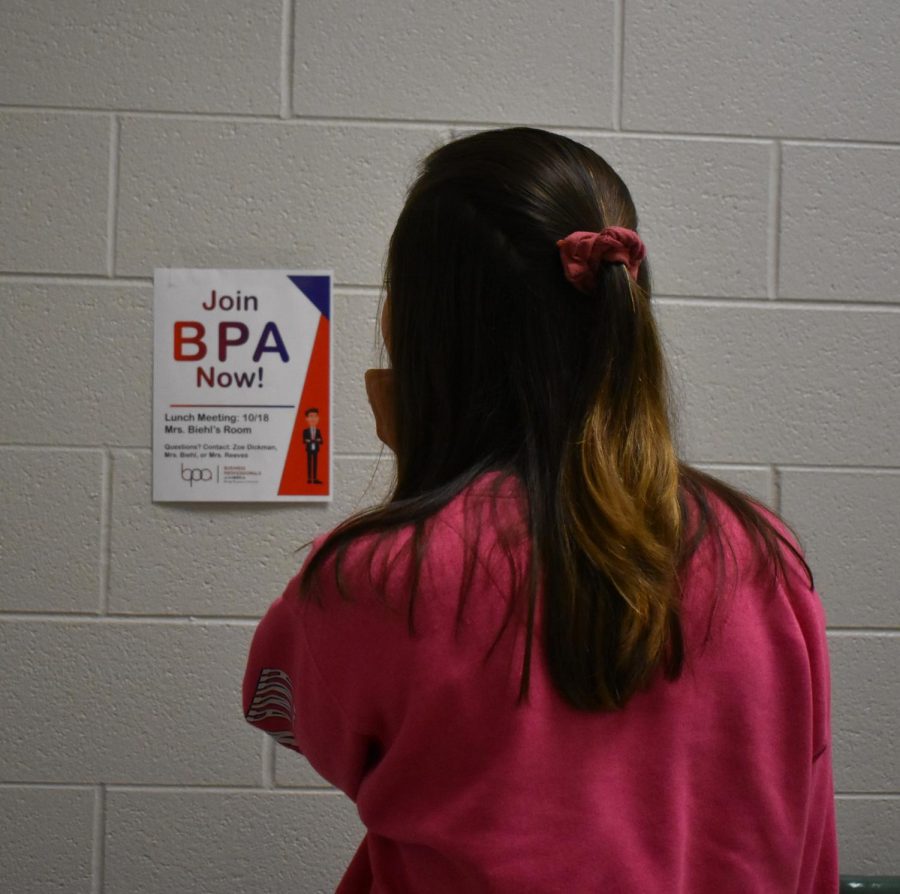 A student examines a poster for a BPA meeting.