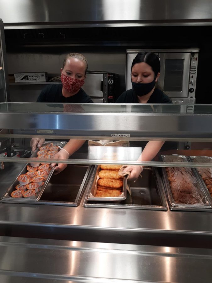 Sarah Head (left) and Ashlynn Head (right) work hard to prepare meals for students.