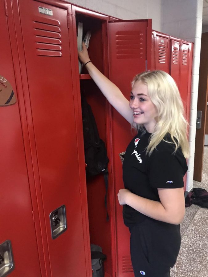 New student collects her things from her locker during passing time. 