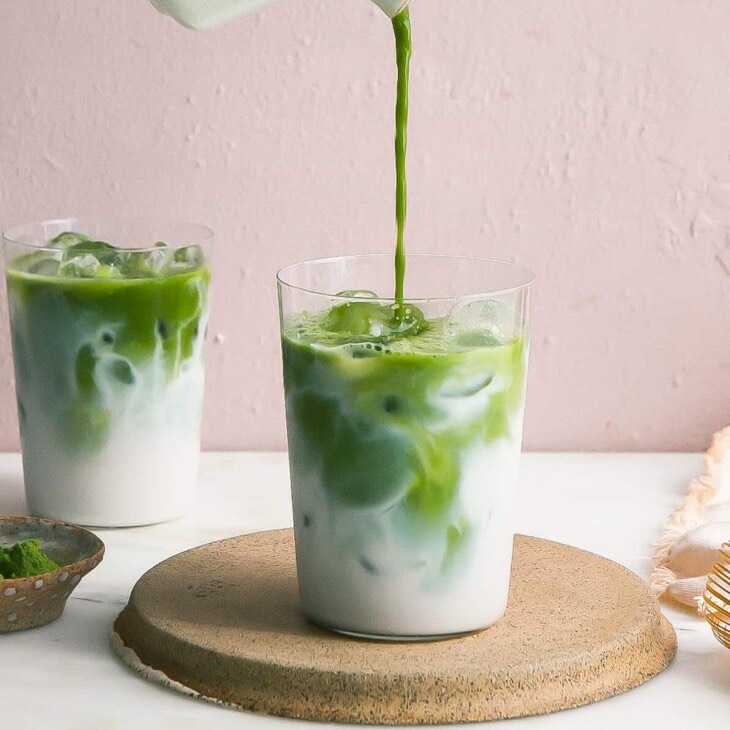 The controversial Matcha Tea is being poured in a glass with milk. 
