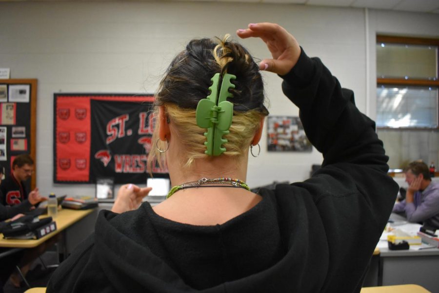 SLHS student places a claw clip in her hair in order to get it out of her face.