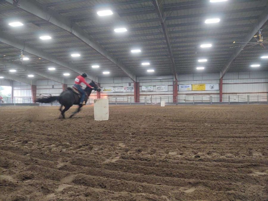Bethany Bowerman rides her horse to complete one barrel runs. 