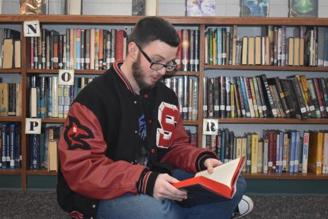 A student at SLHS prepares for book club as he reads a new book. 