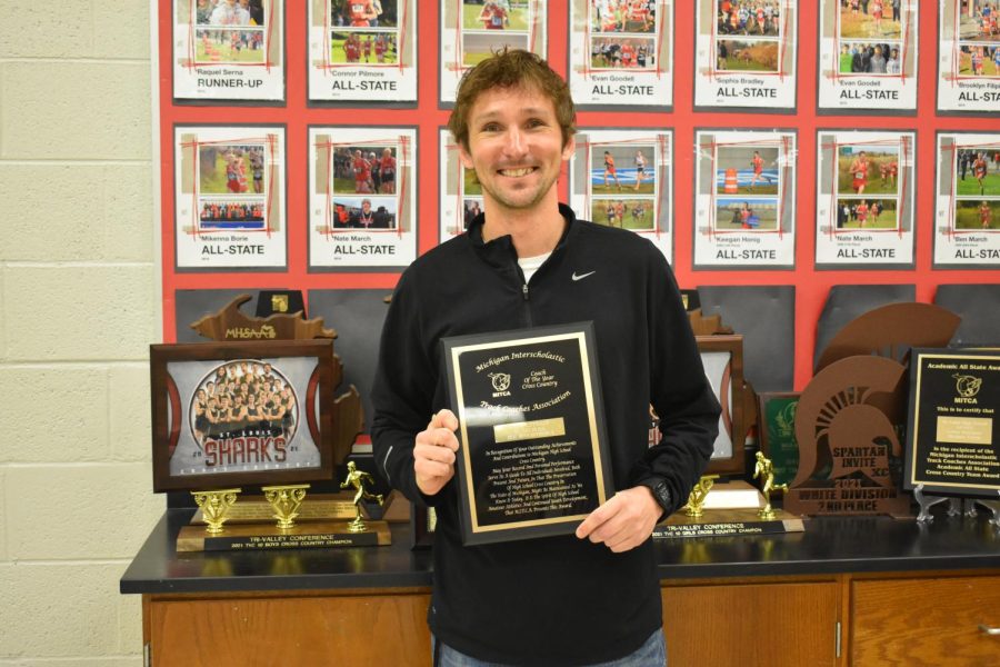 Coach Puffpaff poses with just one of his many plaques over his career.
