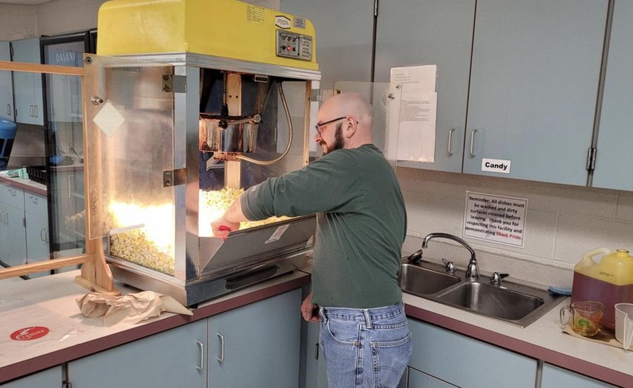 Derek Jewel volunteers to help make popcorn for SLHS. 