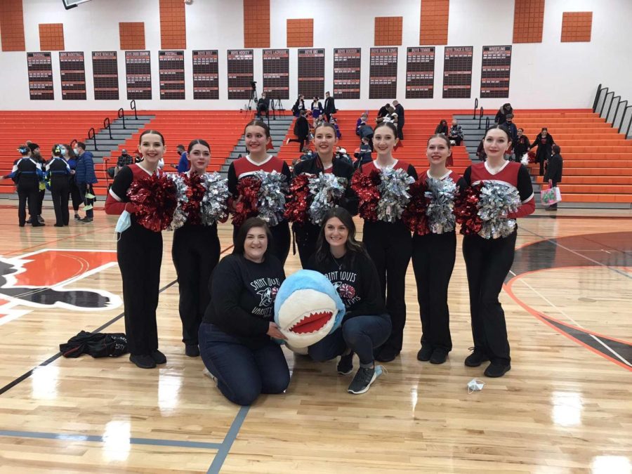 The Poms team poses with shark after qualifying for state.