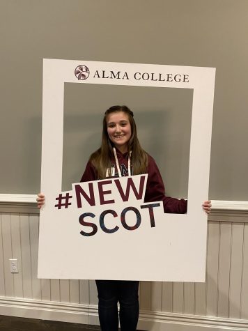 Leah Chvojka poses with a sign showing off her  future college with the Alma Scotts.