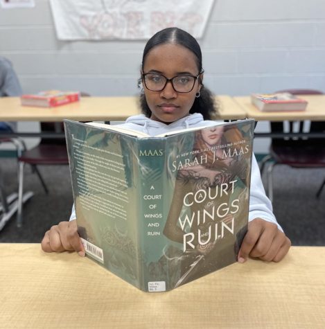 A student reads A Court of Throne and Roses during some free time in class. 
