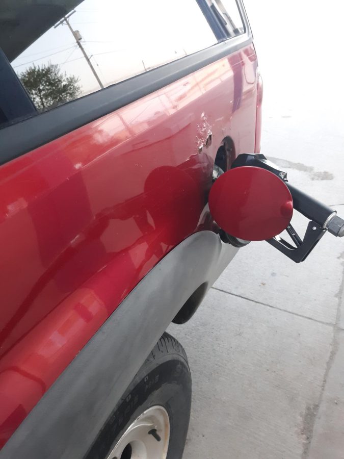 A gas vehicle is filled at a gas station.