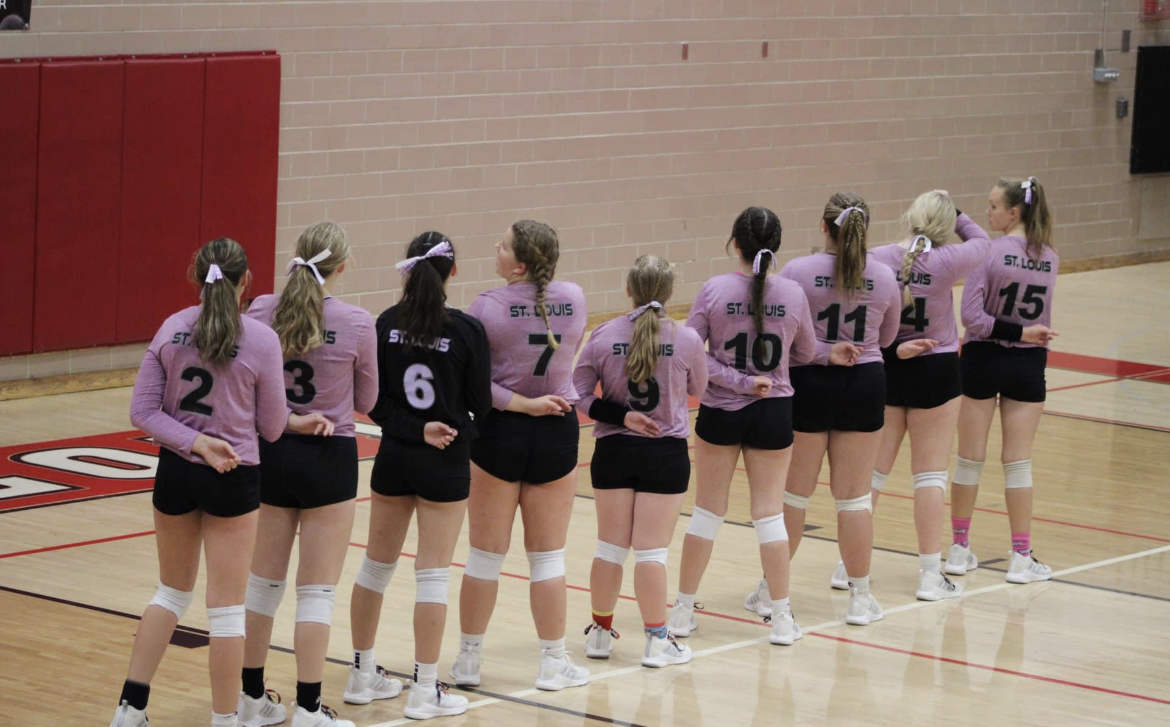 The volleyball girls gather before the game to honor the flag and set a plan in motion.