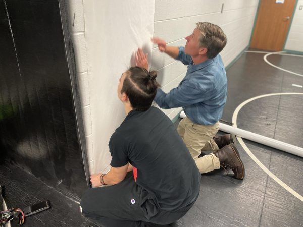 Wrestling coach Kevin Kuhn and future wrestler Kalen Lipka help renovate the wrestling room for the upcoming season.