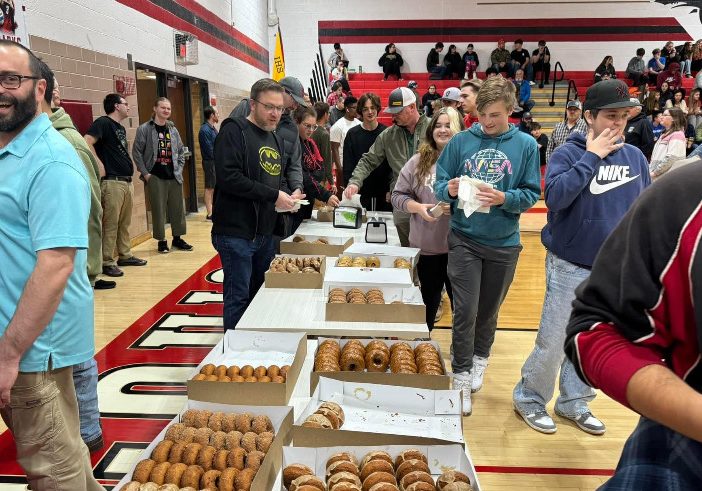 Students line up with their dads to grab a fresh donut!