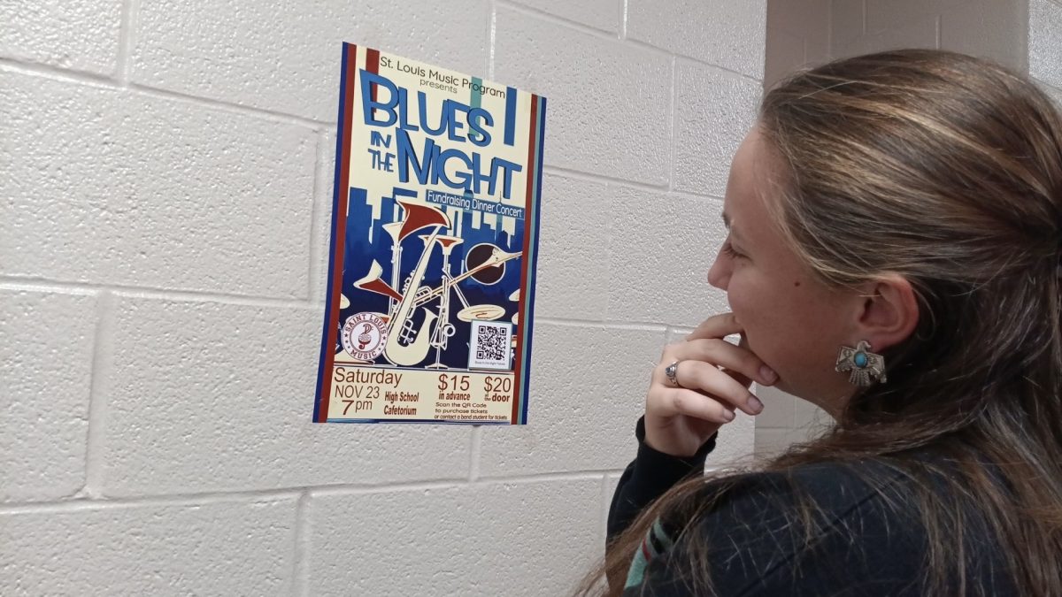 Senior Rebekah Ross looks at the poster for the concert for details.