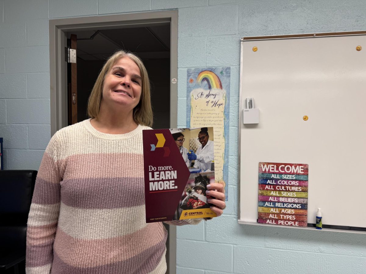 School counselor Terre Sura holds an informational poster for Central Michigan University.