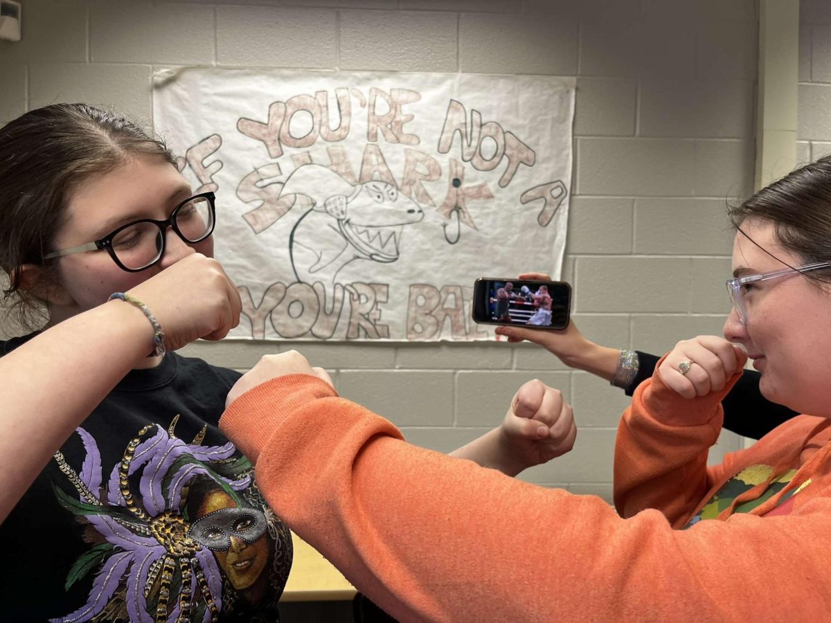 Juniors Sophia Miller and Gracie Lombard reenact a photo taken during the iconic fight.