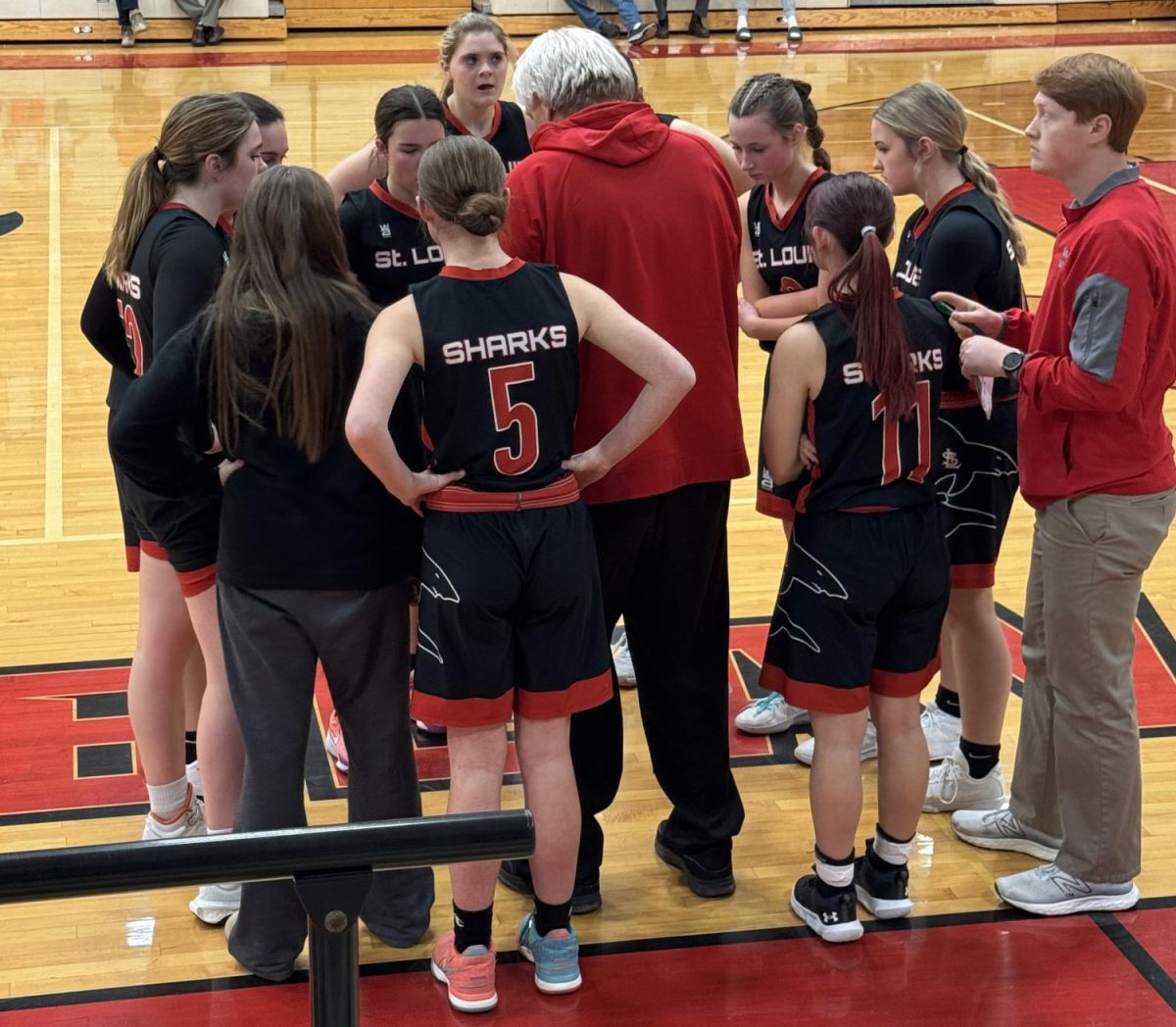 The girls huddle together to strategize their next plays in hopes of winning the game.