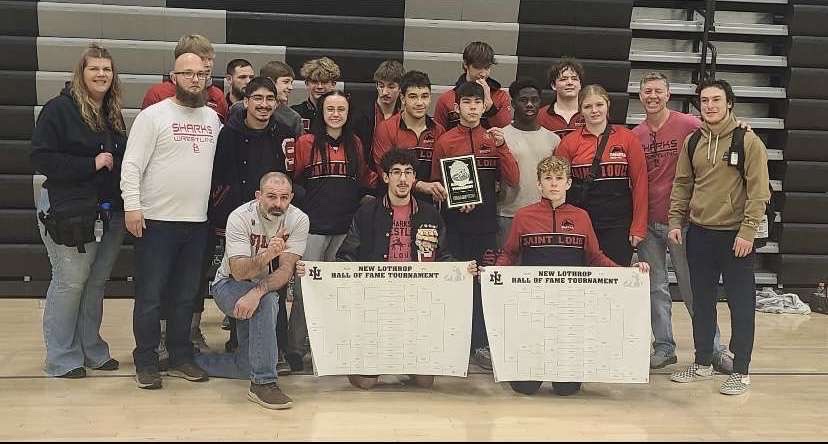 The wrestling team takes a photo together after a successful day of competition.