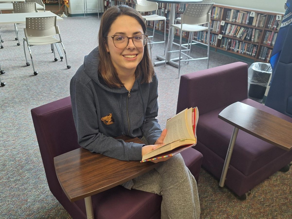 Senior Bethany Bowerman shows her book preference while reading in the library.