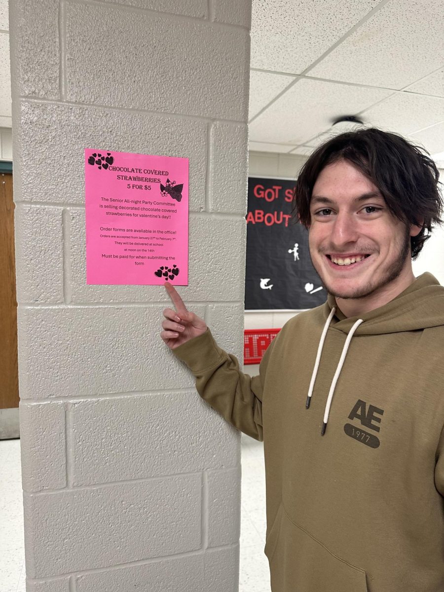 Senior Maddox Cline showcases the poster for chocolate covered strawberries!