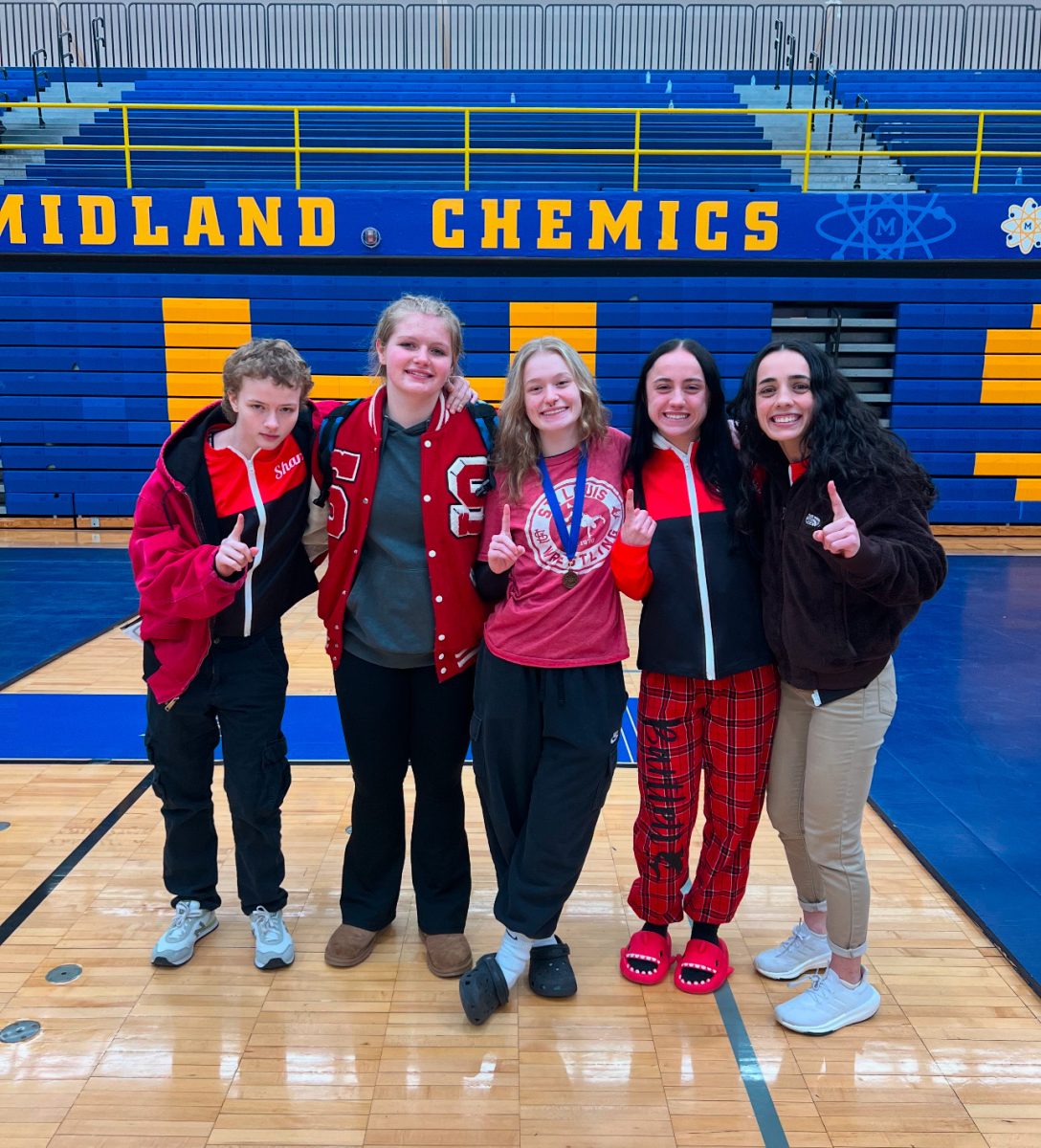 The girls wrestlers take a team photo together after a long day of wrestling.