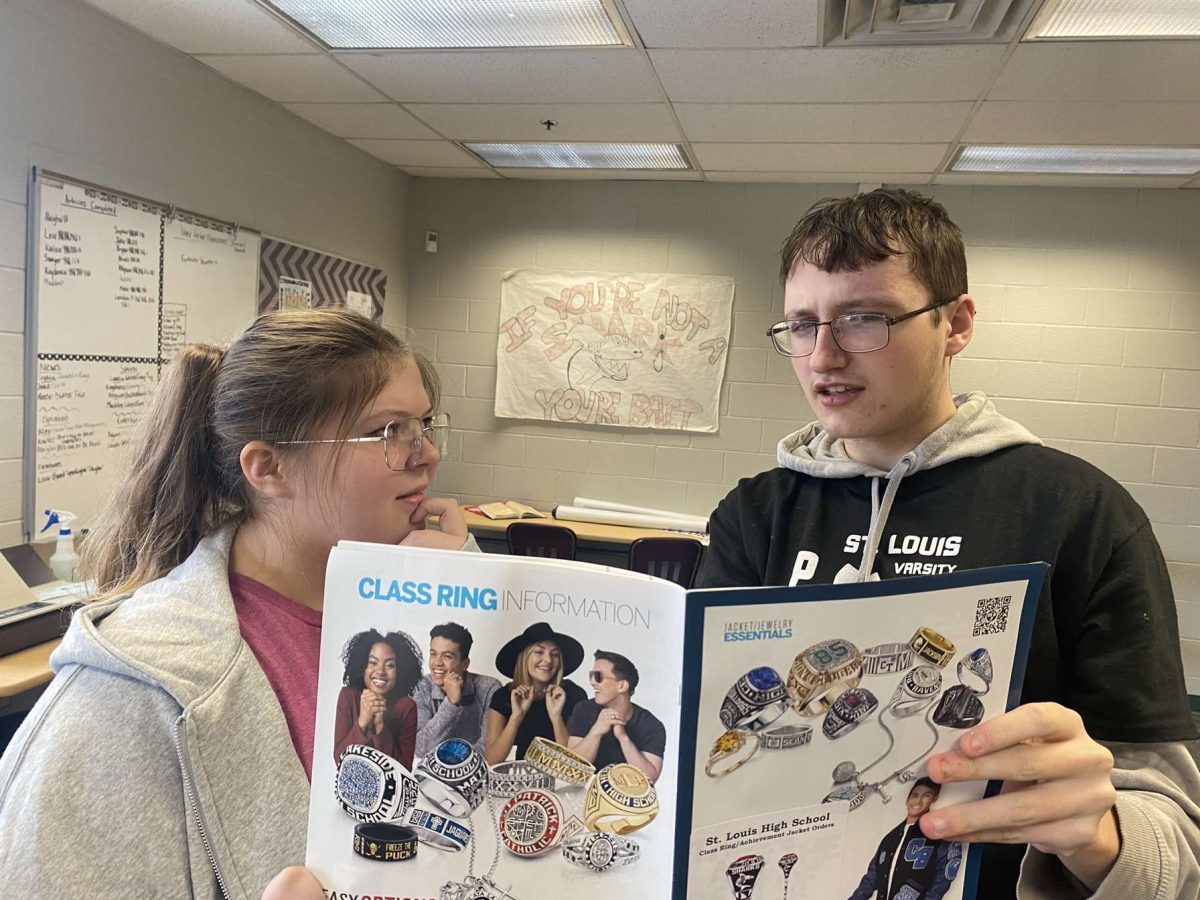 Students Leia Firman and Skylar DuBois-Kleinhans converse over purchasing class rings.