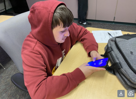 Junior Lucas Zimmerman plays Block Blast on his phone after finishing his school work.