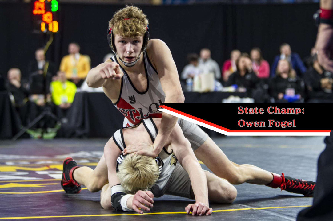 Owen Fogel points at the camera during his wrestling match as he skillfully takes down his opponent. 