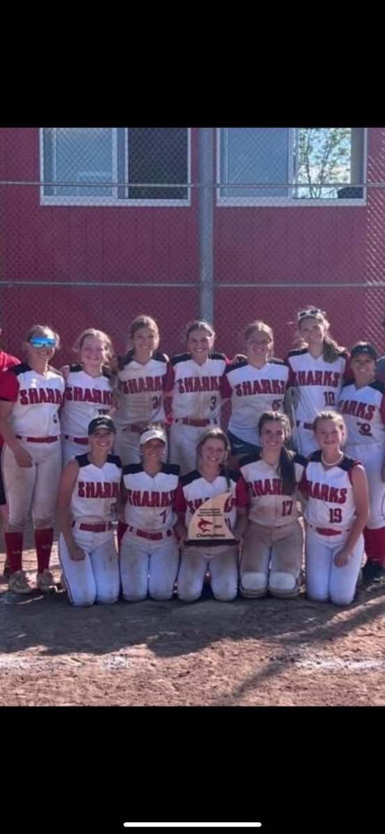 The 2024 softball team poses with their districts trophy.