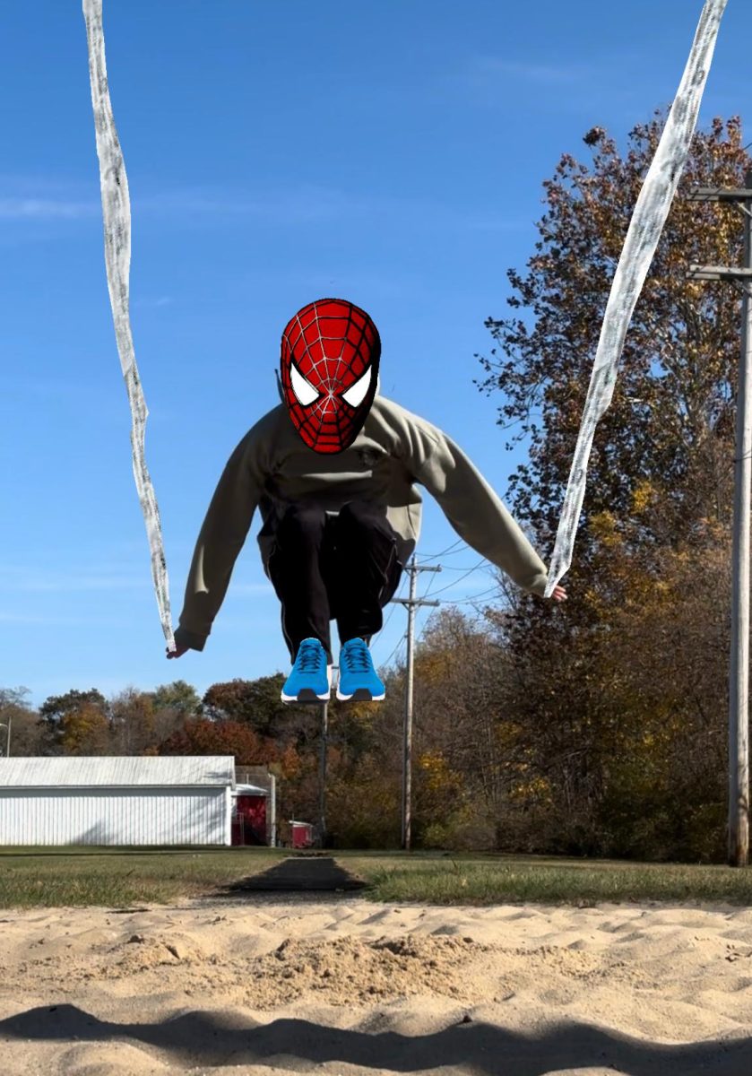 Junior Noah Bobzien pretends to be Spider-man as he long jumps outside. 