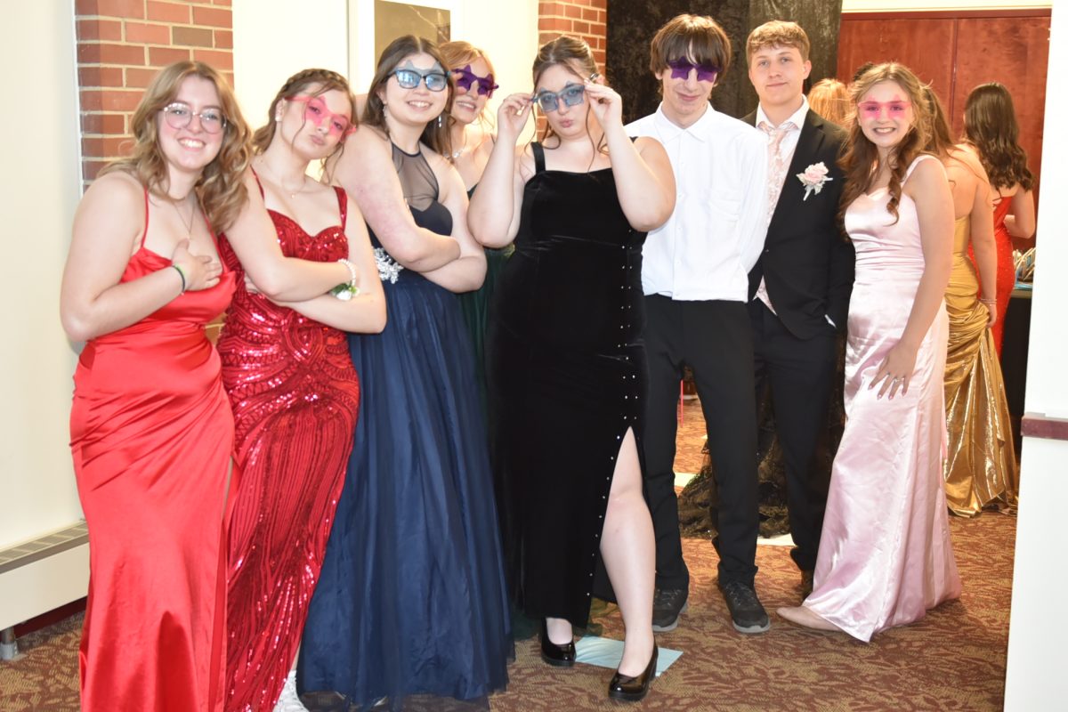 A group of prom attendees poses for the camera while in line for the photo booth.