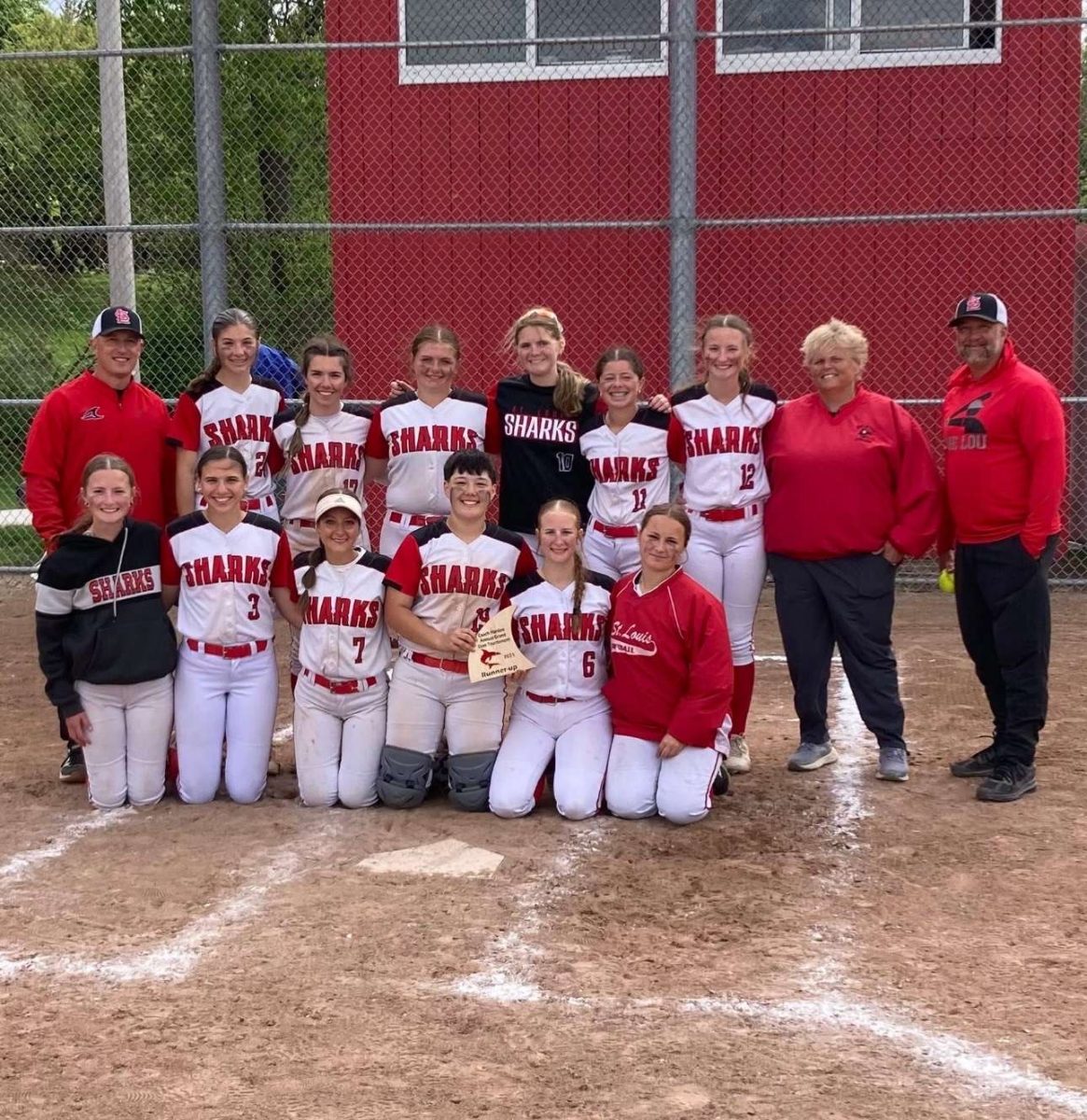 The softball team poses with their runner-up trophy.